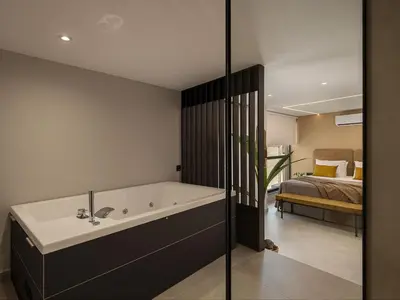 a bathroom with a bath tub next to a bedroom at Theta Boutique Hotel in Chania Town