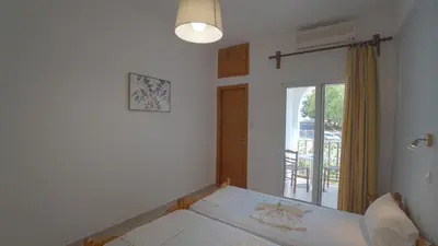 a bedroom with a bed and a window with a view at Ilingas Hotel in Khóra Sfakíon