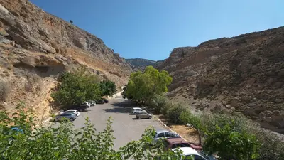 a parking lot with cars parked in a canyon at Ilingas Hotel in Khóra Sfakíon