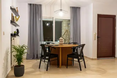 a dining room with a wooden table and black chairs at Ros Solis Luxure House in Chania Town