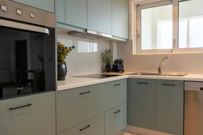 a kitchen with white cabinets and a sink and a window at Ros Solis Luxure House in Chania Town