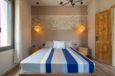 a bedroom with a bed with blue and white stripes at Casa di Batsi in Chania Town
