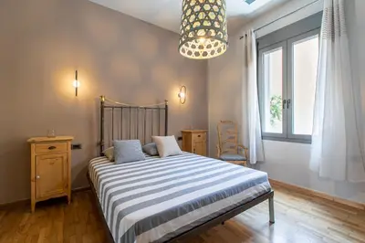 a bedroom with a bed and a chandelier at Casa di Batsi in Chania Town