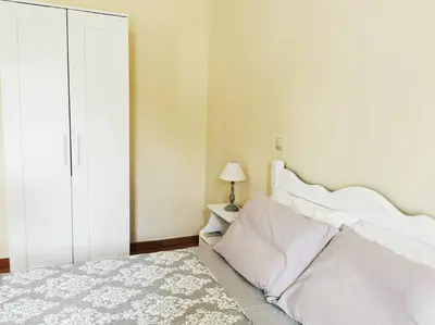 a bedroom with a white bed and a lamp on a table at Leli House in Chania Town