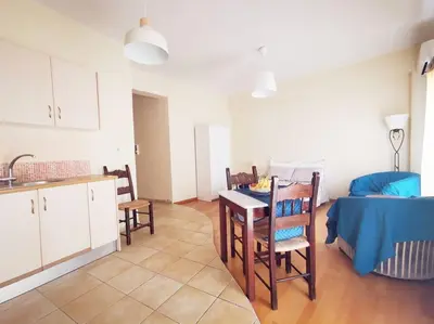a kitchen and living room with a table and chairs at Leli House in Chania Town