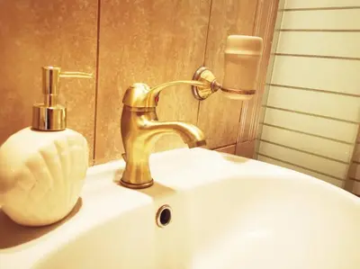 a sink with a gold faucet and a vase on it at Leli House in Chania Town