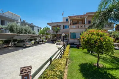 a building with a car parked in a parking lot at Armeria Apartments in Daratso