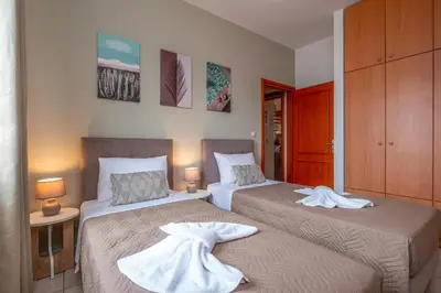 two beds with towels on them in a bedroom at Armeria Apartments in Daratso