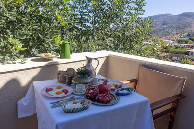 a table with food on it on a balcony at Rimondi Residences Chania in Chania Town