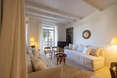 a living room with a white couch and a table at Rimondi Residences Chania in Chania Town
