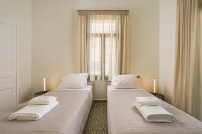 two beds in a room with a window at Tatianas Kanevaro in Chania Town