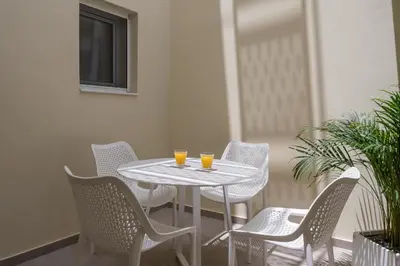 a white table and chairs with two glasses on it at Tatianas Kanevaro in Chania Town