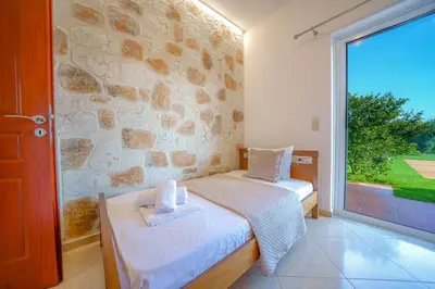 a bedroom with two beds and a large window at Villa Lima Pool & Jacuzzi Chania in Vamos