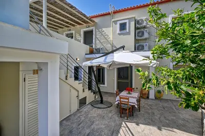 a patio with a table and an umbrella at Haroto Home Residence in Plokamianá