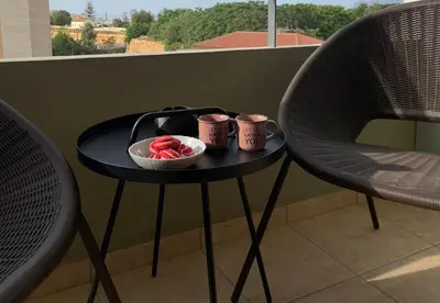 a small black table with two chairs and a bowl of flowers at City Spot Chania in Chania Town