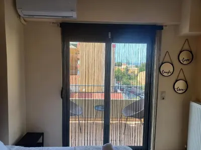 a bedroom with a sliding glass door to a balcony at City Spot Chania in Chania Town