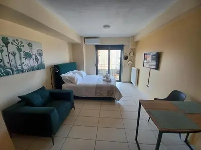 a bedroom with a bed and a couch and a table at City Spot Chania in Chania Town