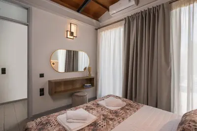 a bedroom with a bed and a mirror at Natura Hill Villa IV Sea View in Kounoupidhianá