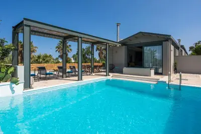 a swimming pool in front of a house at Natura Hill Villa IV Sea View in Kounoupidhianá