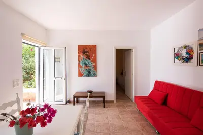 a living room with a red couch and a table at Villa Kiara in Tersanas