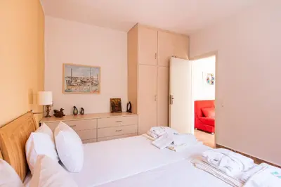 a bedroom with a white bed and a red couch at Villa Kiara in Tersanas
