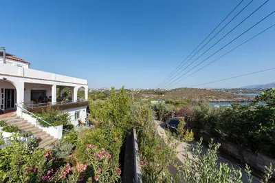 a white house with stairs and flowers on a hill at Villa Kiara in Tersanas