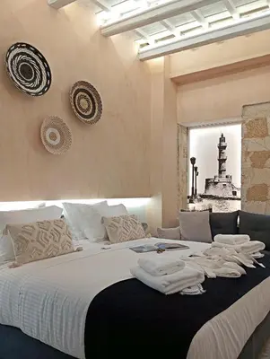 a bedroom with a large bed with towels on it at Domus Vivendi in Chania Town