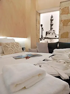 a bedroom with a bed with white sheets and a lighthouse at Domus Vivendi in Chania Town