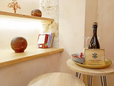 a bottle of wine on a shelf next to a chair at Domus Vivendi in Chania Town