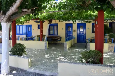 a building with blue doors and a table at Vrachos Apartments in Frangokastello