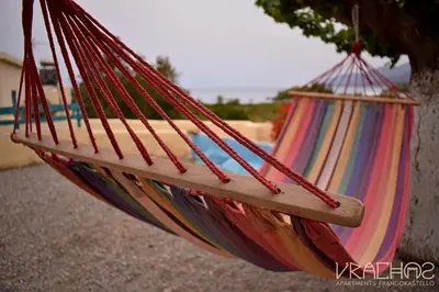 a colorful hammock hanging from a tree at Vrachos Apartments in Frangokastello