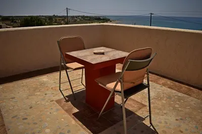 a small table and two chairs on a balcony at Pasithea in Frangokastello