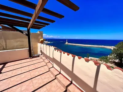 a view of the ocean from the balcony of a house at Talos Too, Venetian Residence in Chania Town