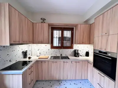 a kitchen with wooden cabinets and a sink and a window at Talos Too, Venetian Residence in Chania Town