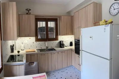 a kitchen with a refrigerator and a clock on the wall at Talos Too, Venetian Residence in Chania Town
