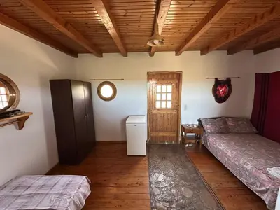 a bedroom with two beds and a wooden ceiling at Koumos in Kalyves