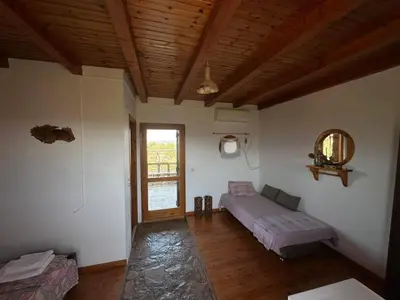 a living room with a bed and a window at Koumos in Kalyves