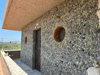 a stone wall with a door in the side of a building at Koumos in Kalyves