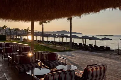 a restaurant with chairs and tables and a view of the ocean at Atlantica Kalliston Resort - Adults Only in Stalos