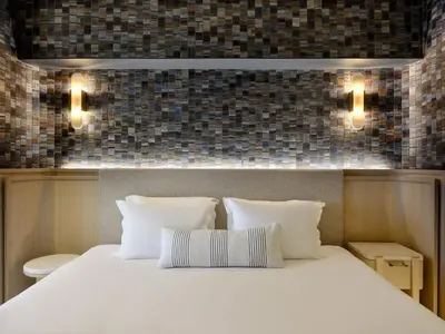 a bedroom with a large white bed with two pillows at Atlantica Kalliston Resort - Adults Only in Stalos