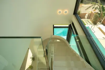 a staircase in a house with a glass wall at Luxury Villa Mirror - 200meters From The Beach in Daratso