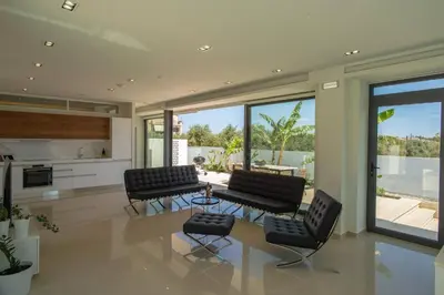 a living room with two chairs and a table at Luxury Villa Mirror - 200meters From The Beach in Daratso