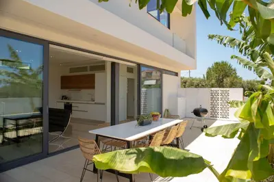 a patio with a table and chairs on a balcony at Luxury Villa Mirror - 200meters From The Beach in Daratso