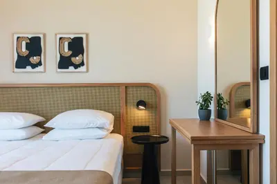 a bedroom with a bed and a table and a mirror at Petras Luxury Villas in Falasarna