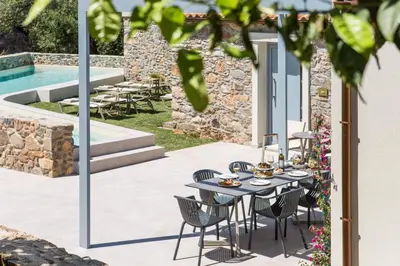 a patio with a table and chairs next to a pool at Evge Experience Boutique Hotel in Kafoúros