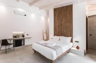 a bedroom with a large bed and a desk at Evge Experience Boutique Hotel in Kafoúros