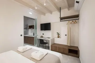 a small bedroom with a bed and a kitchen at Evge Experience Boutique Hotel in Kafoúros