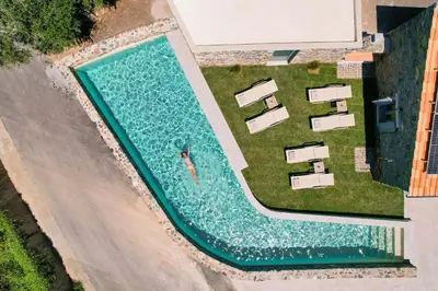 an overhead view of a swimming pool with chaise lounges at Evge Experience Boutique Hotel in Kafoúros