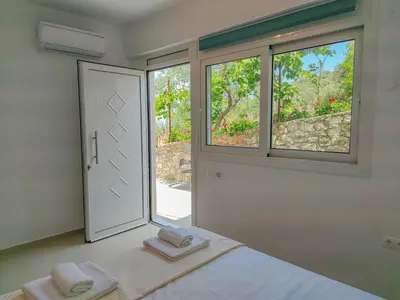 a bedroom with a bed and a window with towels at Fully renovated Studio in Platanias in Plataniás