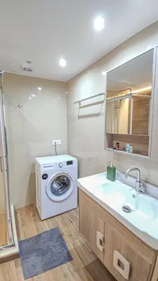 a bathroom with a washing machine and a sink at Fully renovated apartment in Platanias 1 in Plataniás